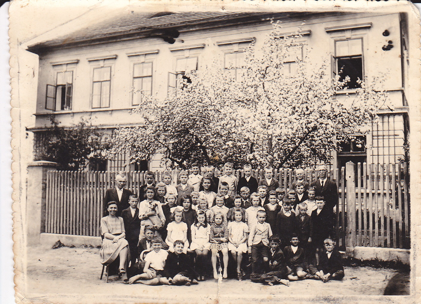 Historická fotografie žáků školy před školou.